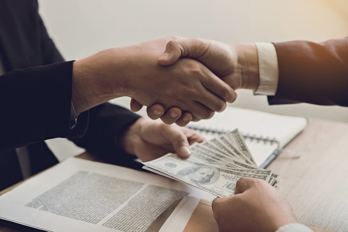 Businessmen Shaking Hands and Paying Money Concept